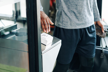 Obraz premium Close-up image of sportsman pushing special big button to open the door and leave gym building
