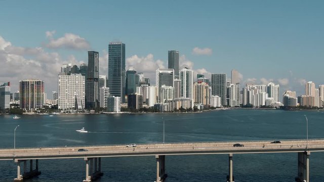 Wide aerial drone flying over bridge & water towards downtown Miami 4k