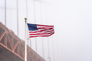 USA flag with Golden Gate Bridge in the fog, San Francisco.