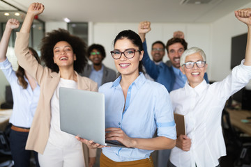 Happy business people celebrating success at company