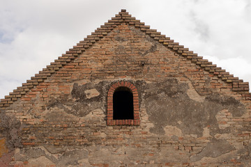 Roof wind window of an old brick building against the sky.