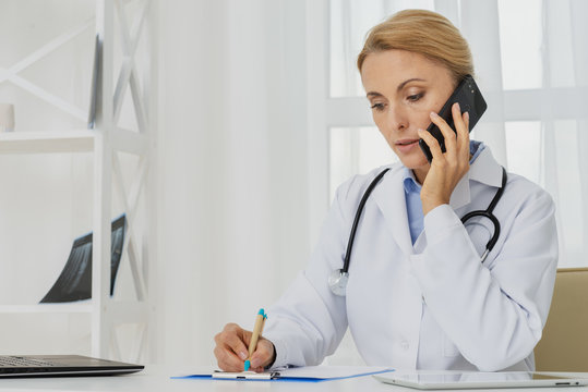 Doctor talking on the phone sitting at desk