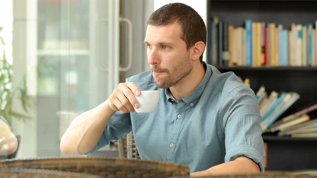 Serious man drinking coffee and looking away in a restaurant