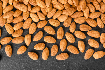 Almonds background. Fresh nice almonds from top view, on dark stone table.