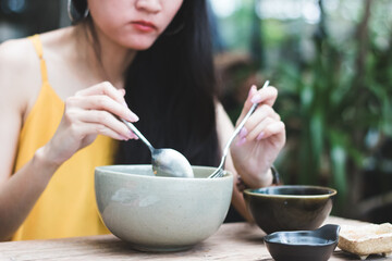 Close up of young Asian woman is eating in the restaurant.