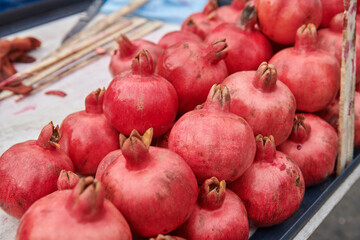 A bunch of pomegranates at the market. Ripe fruits on the table. Natural organic products.