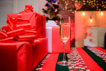 Glass filled sparkling wine or champagne near gift boxes. Celebrate new year. Glass of champagne close up. New year traditional attribute. Happy new year and merry christmas. Champagne elegant glass