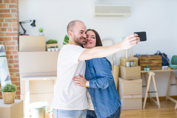Obraz premium Young couple taking a picture photo using smartphone at new home, smiling happy for moving to new apartment