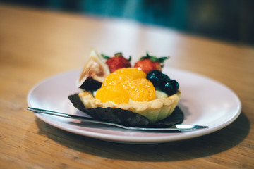 Close up of fruit tart on the wooden table.