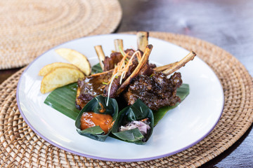 Grilled pork ribs with Indonesian style sauce on the plate. Indonesian cuisine.