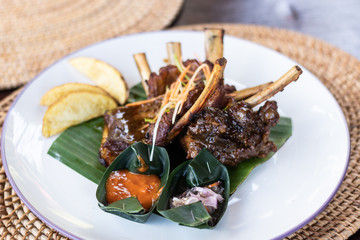 Grilled pork ribs with Indonesian style sauce on the plate. Indonesian cuisine.