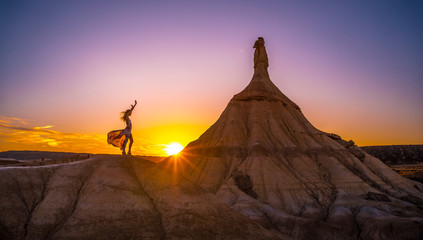 Sunset in the Bardenas Reales of a young blonde in a white dress with flowers, Navarra. Spain, lifestyle session