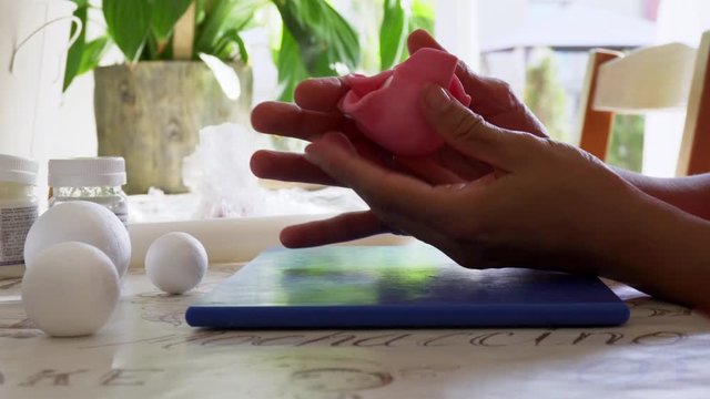 Confectioner covering the polystyrene ball with edible sugar paste for a birthday cake