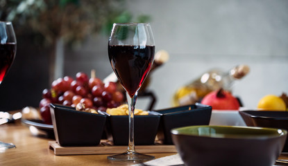 Pouring wine into glass and food background