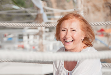 Close up portrait of a happy smiling mature woman Relaxing on the beach by the sea.