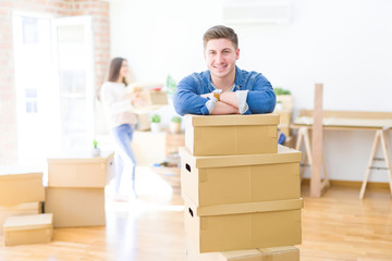 Beautiful young couple moving to a new home, young man smiling happy to the camera excited for new apartment