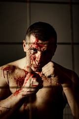 Strong aggressive monster behind grid. Bodybuilder nude torso soiled blood. Prison for monster. Psycho mad man. Psychic disease. Murderer brutal aggressive guy. Fight and attack. Aggressive person