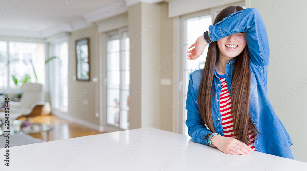 Sticker young beautiful asian woman with long hair wearing denim jacket covering eyes with arm smiling cheer