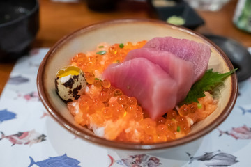 Close up of Tekkadon (Tuna bowl) on the table, fresh sashimi, raw tuna and salmon roe.