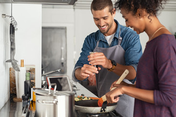 Man adding pepper in tomato sauce