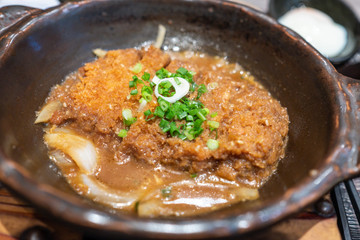 Crispy fried pork or Tonkatsu with miso sauce in the bowl. Japanese food.
