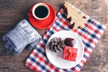Topview red gift box with coffee cup and glay glove decorate with glay glove and small christmas tree.