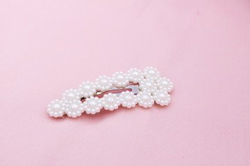 Luxury hair clip on pink fabric with copyspace.