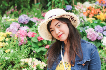 Close up of young Asian woman with blur flower background.