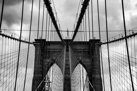 Brookyln Bridge New York Manhattan schwarz wei&szlig; grafik Graustufen Himmel Wolken Konstruktion Ingenieur East River Sehensw&uuml;rdigkeit Wahrzeichen Tragseile Statik B&ouml;gen Pilon Pfeiler Mauerwerk Symmetrie