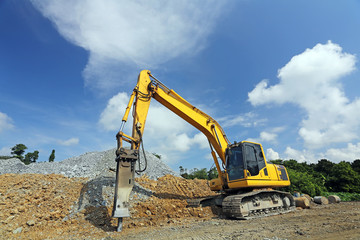 Yellow backhoe working scoop rock dig a large well or Industrial excavator loading soil material from the garden