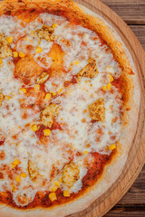 Hawaiian pizza on dark rustic wooden background. Top view, copy space