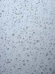 Raindrops on the window glass in opposite light