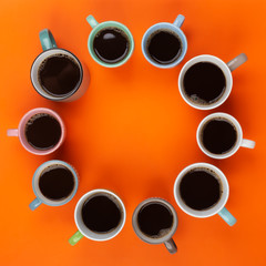 Coffee in the different cups on the bright orange background. Flatlay, cheerful day concept with copy space
