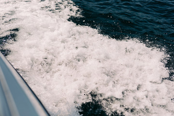 sea waves bubble foam from boat. Water spray from boat wake