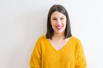Fototapeta premium Beautiful brunette young woman smiling confident and cheerful over isolated white background wearing casual yellow sweater