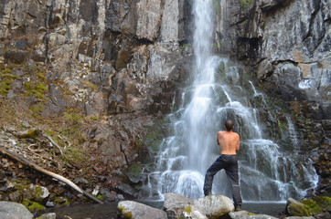 young man in the waterfall