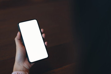 Closeup of woman holding a smartphone, mock up of blank screen. using cell phone on cafe. Technology for communication concept.