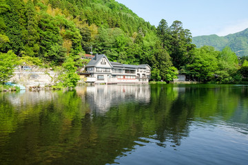 Fototapeta na wymiar Landscape of The Kinrin Lake with surrounded by trees in Background and water reflection, onsen town, Yufuin, Oita, Kyushu, Japan.