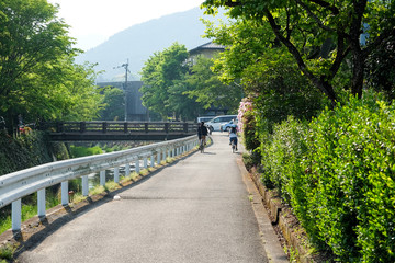 The Asphalt road to Kinrin Lake with Mount Yufu in Background and blue sky with clouds in summer. onsen town, Yufuin, Oita, Kyushu, Japan.