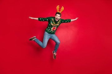 Fototapeta na wymiar Shopping I'm coming. Full size photo of funny jumping guy spread arms pretending flight wear pullover with ugly ornament isolated red color background