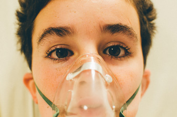un enfant asthmatique avec un masque à oxygène  
