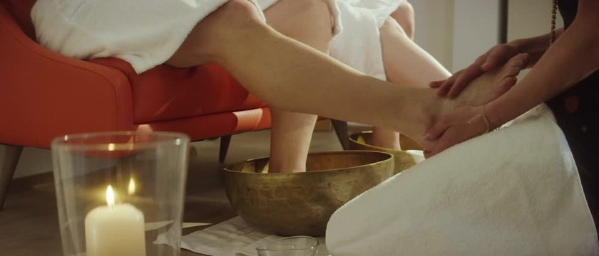 a masseuse giving a foot massage to a man with the aid of a golden bowl - Eine Masseuse gibt einem Mann eine Fu&szlig;massage mithilfe einer goldenen Sch&uuml;ssel