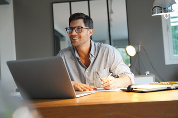 smiling man working in an office.