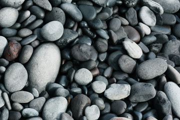 Volcanic stones on ocean shore, cold clean water, waves, Madeira island, Portugal