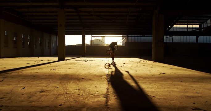 BMX rider in an empty warehouse