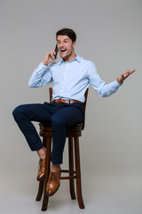 Full length portrait of happy businessman talking on cellphone