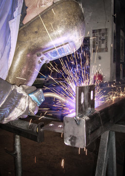 Metallbauer schwei&szlig;t Lasche an ein gro&szlig;es Stahlrohr