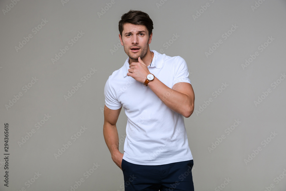 Sticker Image of masculine brunette man looking at camera and touching his chin