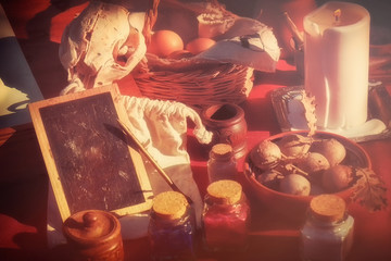 Skull, candle and other magical components for Halloween. A flask, a bottle, a vial, eggs and...
