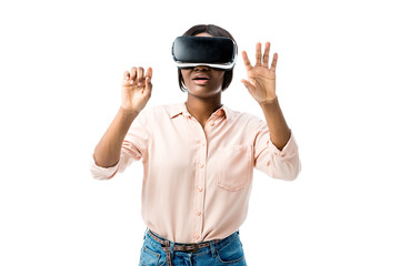 shocked african american woman in shirt with virtual reality headset showing hands isolated on white
